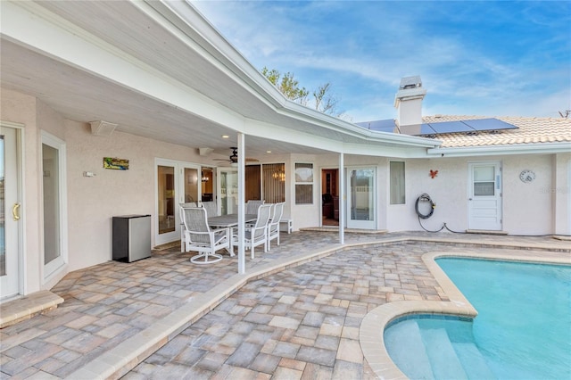 view of swimming pool featuring ceiling fan and a patio