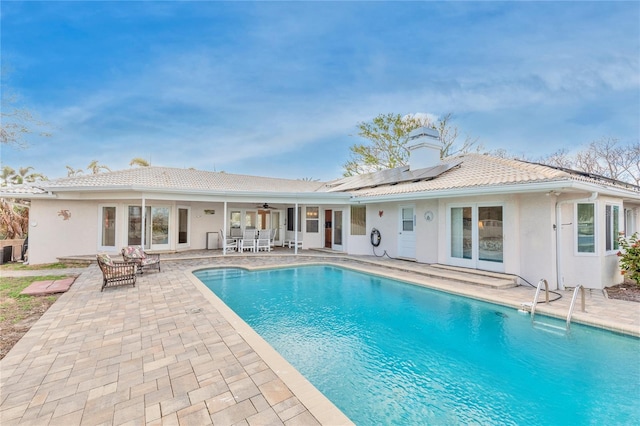 view of swimming pool with ceiling fan, cooling unit, and a patio