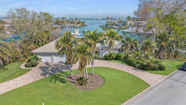 view of front of property with a front lawn, a water view, and a garage