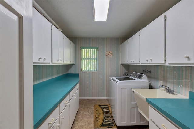 laundry area featuring washer and clothes dryer, light tile patterned floors, and cabinets