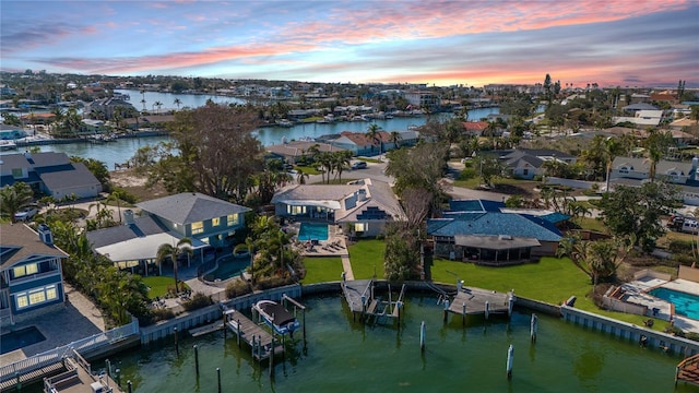 aerial view at dusk featuring a water view