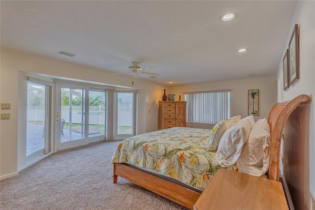 carpeted bedroom with access to exterior, a textured ceiling, and ceiling fan