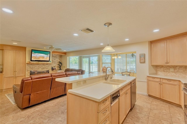 kitchen with light brown cabinets, a kitchen island with sink, and sink