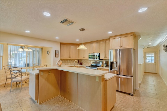 kitchen with decorative backsplash, light brown cabinets, hanging light fixtures, and appliances with stainless steel finishes