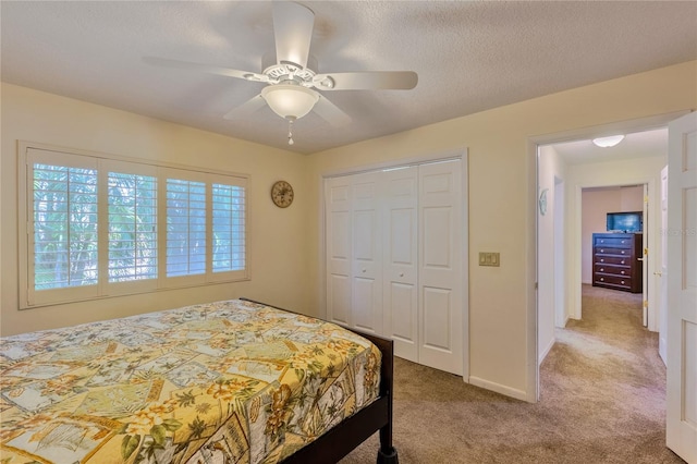 carpeted bedroom with a textured ceiling, a closet, and ceiling fan