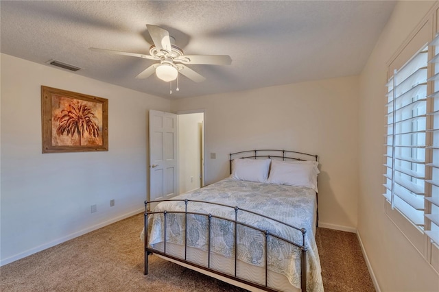 carpeted bedroom with ceiling fan and a textured ceiling