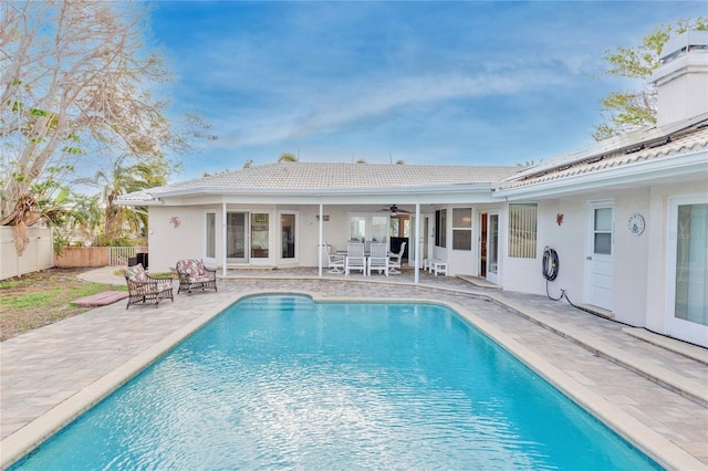 view of swimming pool with ceiling fan and a patio