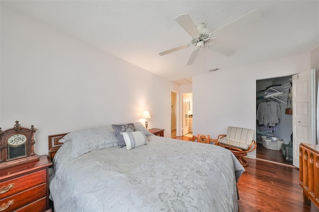 bedroom featuring a closet, ceiling fan, dark hardwood / wood-style flooring, and a textured ceiling