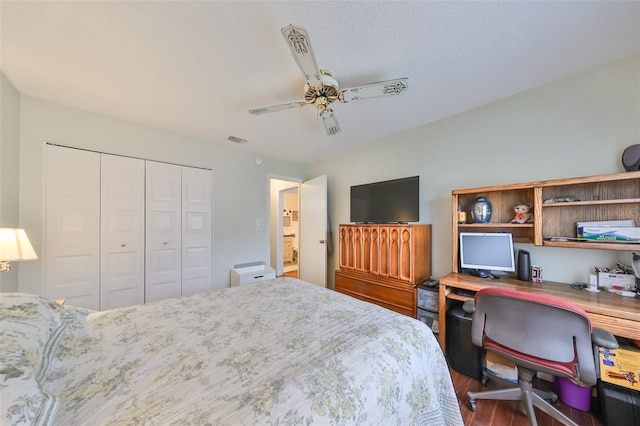 bedroom featuring wood-type flooring, a textured ceiling, a closet, and ceiling fan