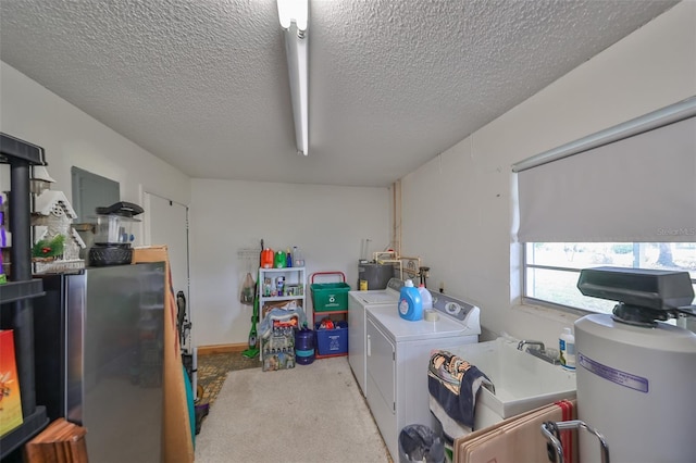 washroom featuring light carpet, sink, washer and dryer, and a textured ceiling