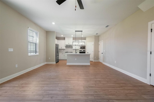 7757 Somersworth Dr, Kissimmee, FL 34747 - unfurnished living room featuring ceiling fan, light wood-style flooring, and recessed lighting