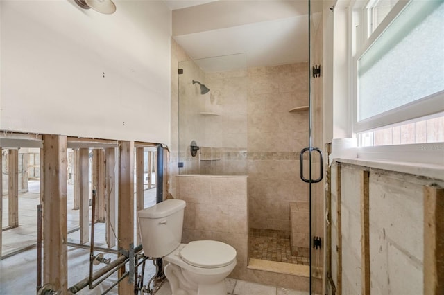 bathroom featuring toilet and a shower with door