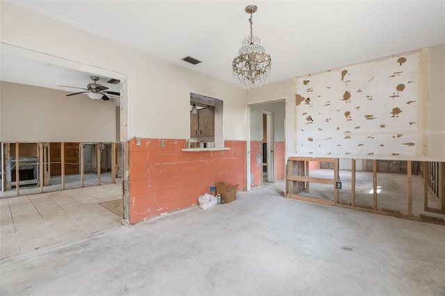 spare room featuring ceiling fan with notable chandelier