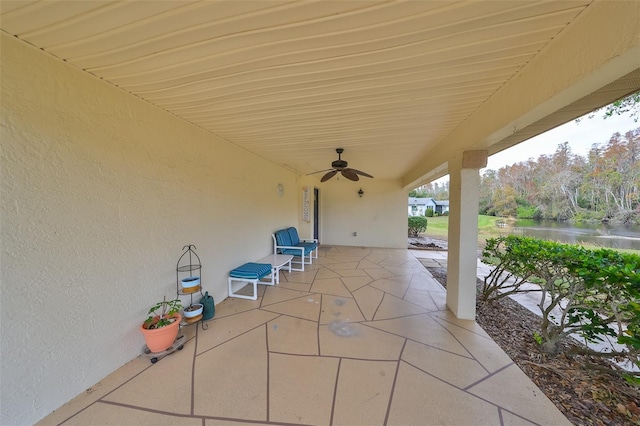 view of patio / terrace featuring a water view and ceiling fan