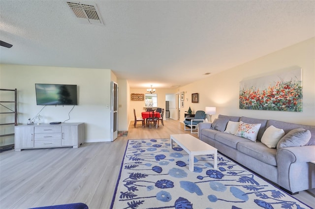 living room featuring light hardwood / wood-style floors and a textured ceiling