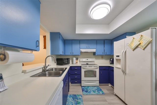 kitchen featuring sink, light hardwood / wood-style flooring, blue cabinets, white appliances, and a tray ceiling