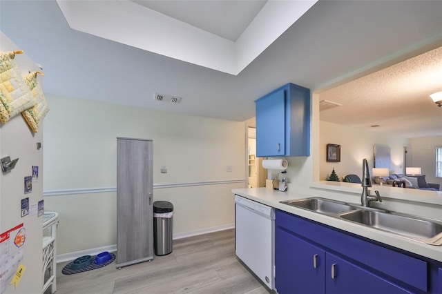 kitchen featuring sink, dishwasher, light hardwood / wood-style floors, and blue cabinets