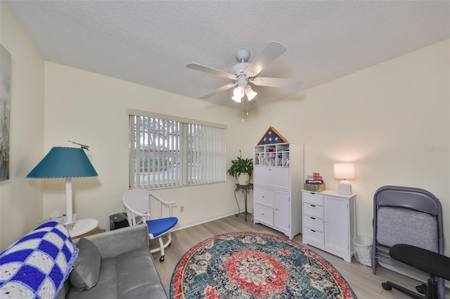 home office featuring a textured ceiling, light hardwood / wood-style floors, and ceiling fan