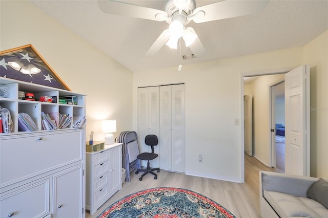 home office with ceiling fan, a textured ceiling, and light wood-type flooring