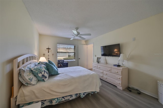 bedroom with a textured ceiling, hardwood / wood-style flooring, and ceiling fan