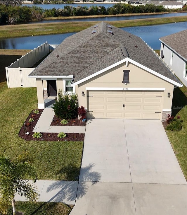 view of front of home with a garage, a water view, and a front yard