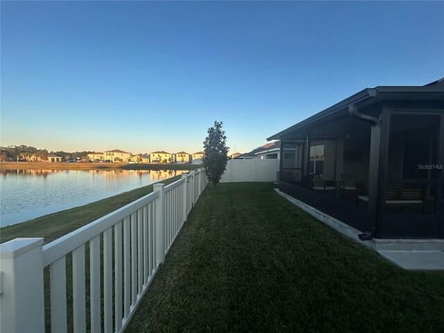 view of yard with a water view and a sunroom