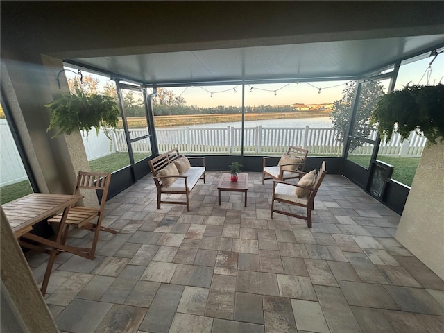 sunroom featuring a water view