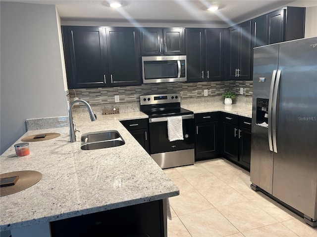 kitchen featuring light stone countertops, sink, stainless steel appliances, backsplash, and kitchen peninsula