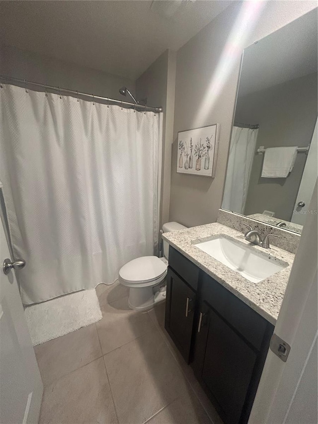 bathroom featuring toilet, vanity, and tile patterned floors