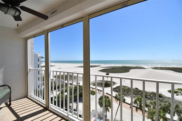 exterior space featuring a water view, ceiling fan, a beach view, and plenty of natural light