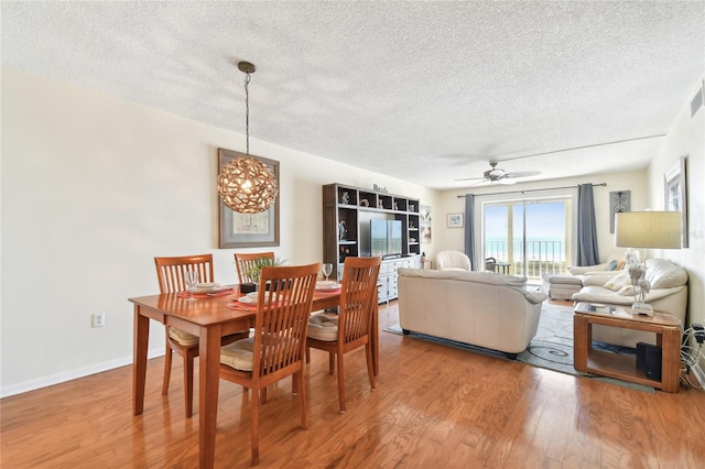 dining room with hardwood / wood-style flooring, a textured ceiling, and ceiling fan