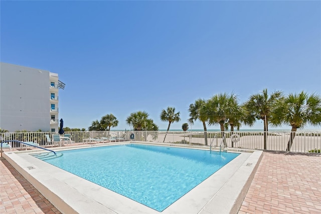 view of swimming pool with a patio area and a water view