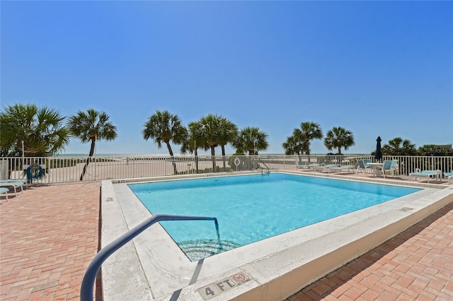 view of pool with a patio and a water view