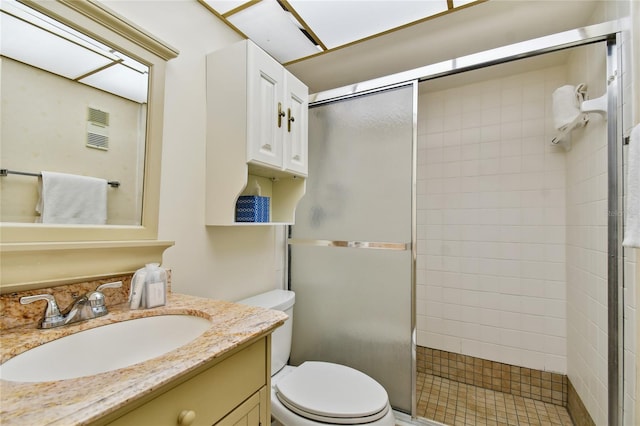 bathroom with vanity, toilet, and a shower with door