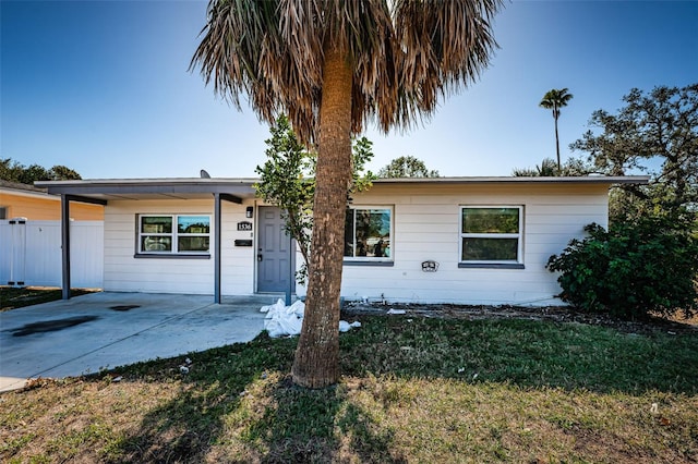 ranch-style home featuring a front lawn and a carport