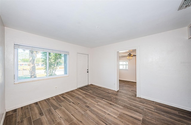 empty room with ceiling fan and dark hardwood / wood-style floors