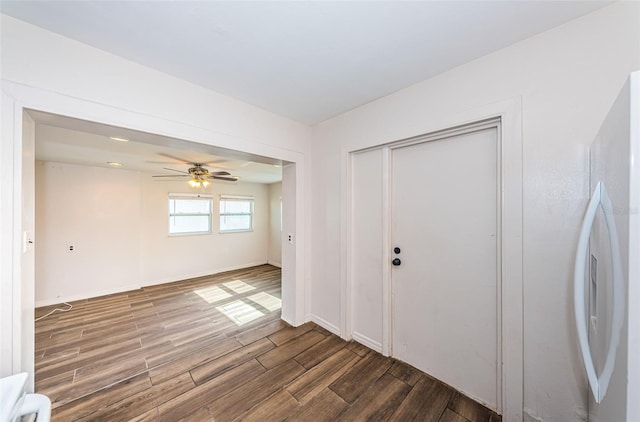 interior space featuring white fridge, ceiling fan, and dark wood-type flooring