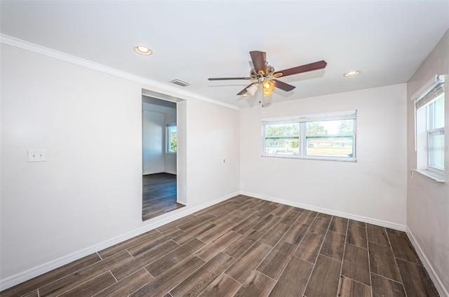 spare room featuring crown molding, ceiling fan, and dark wood-type flooring