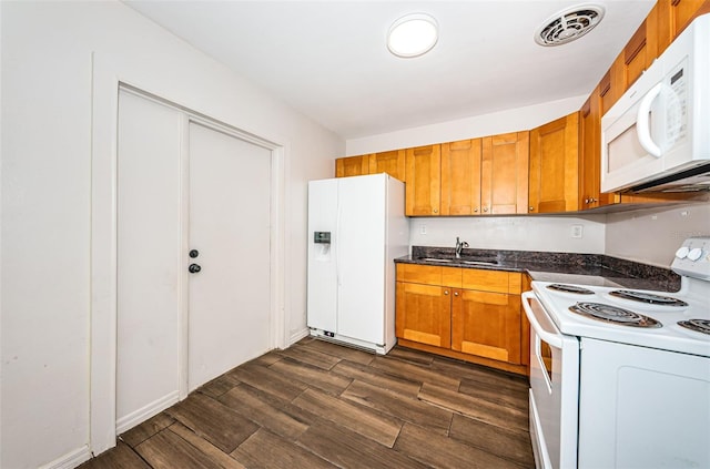 kitchen with sink, white appliances, and dark wood-type flooring