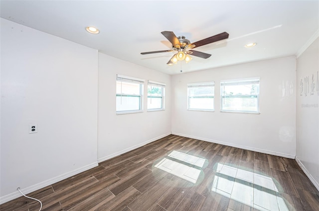 unfurnished room with ceiling fan, a healthy amount of sunlight, and dark wood-type flooring