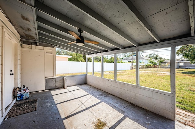 unfurnished sunroom featuring plenty of natural light, ceiling fan, and vaulted ceiling