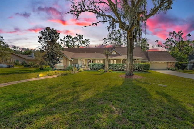 single story home featuring a garage and a lawn