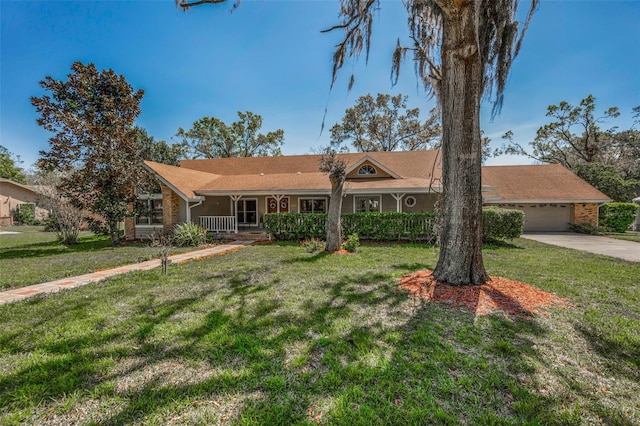 single story home with covered porch, concrete driveway, and a front yard