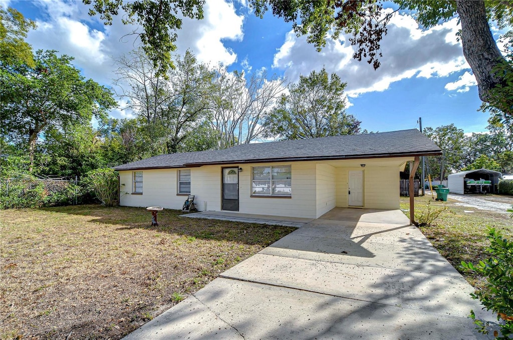 single story home featuring a carport and a front lawn