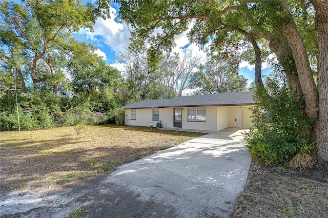 ranch-style house featuring a carport and a front lawn