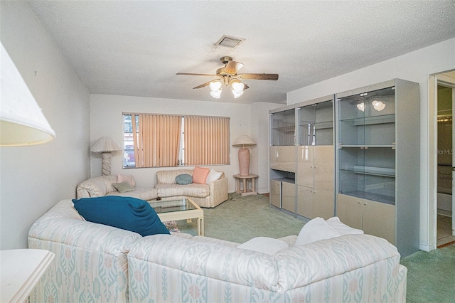 carpeted living room with ceiling fan and a textured ceiling