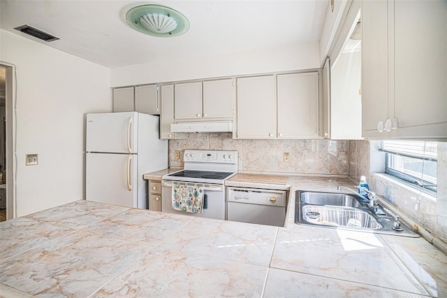 kitchen featuring decorative backsplash, white appliances, and sink