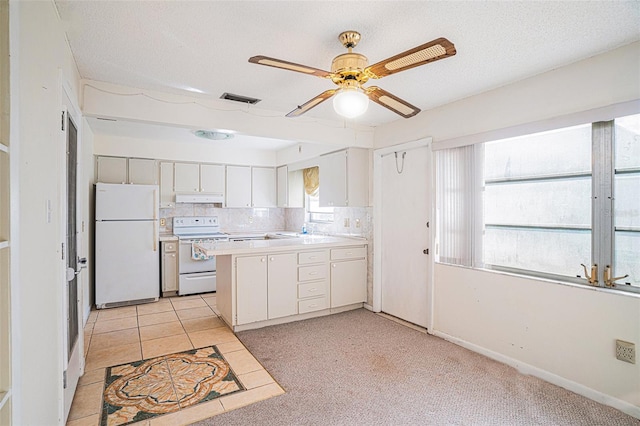 kitchen featuring white refrigerator, white cabinetry, a wealth of natural light, and range with electric cooktop