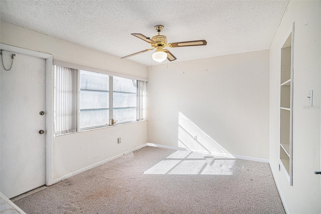 carpeted spare room featuring ceiling fan and a textured ceiling