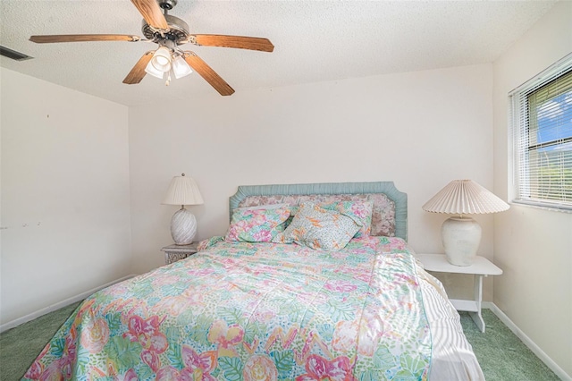 carpeted bedroom featuring a textured ceiling and ceiling fan